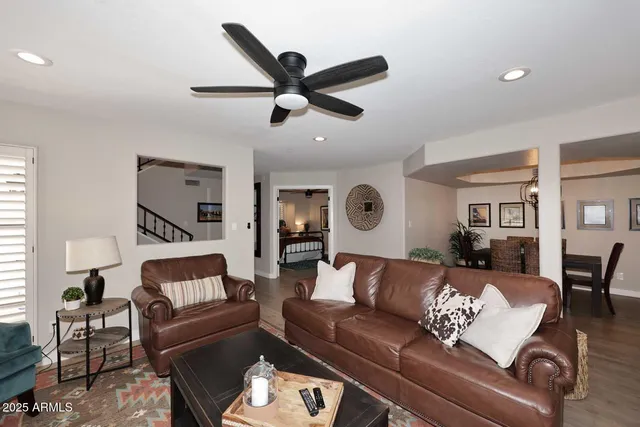 a living room with furniture and a ceiling fan