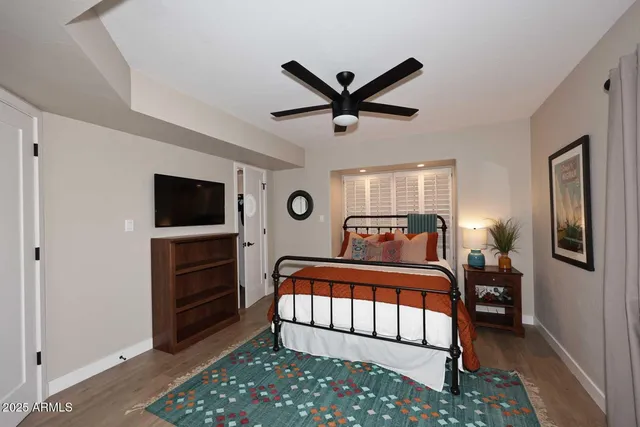 a bedroom with a bed and a tv on the dresser