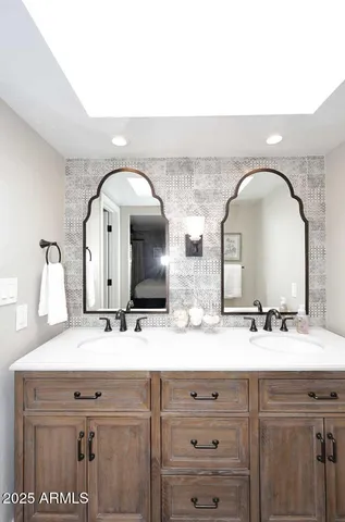 a bathroom with double vanity sinks and a mirror