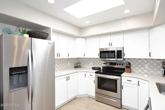 a kitchen with stainless steel appliances a refrigerator stove and microwave