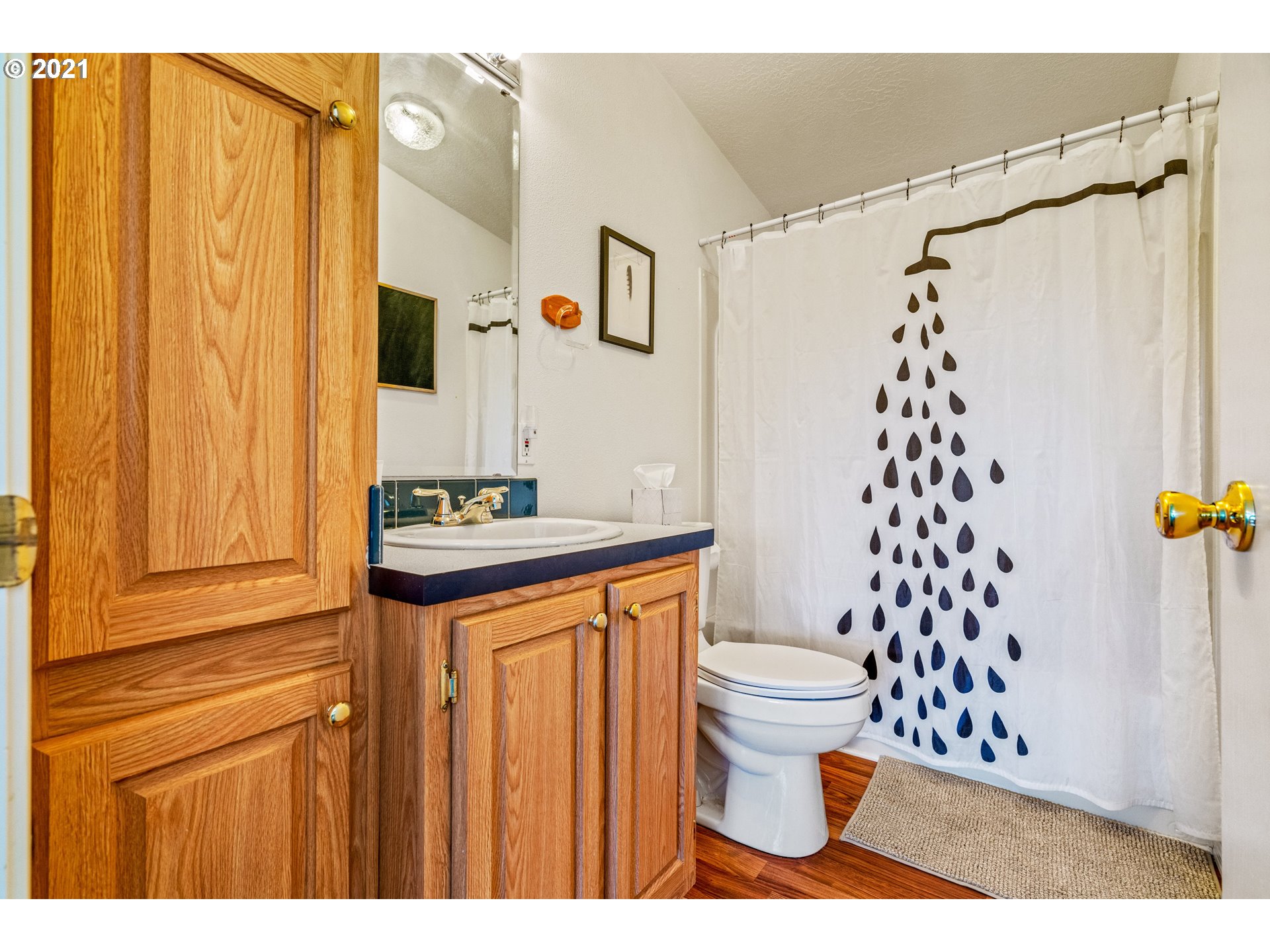 15010 Ferns Corner Road Dallas, OR 97338 - Photo 19 of 32 a bathroom with a sink a toilet and shower curtain