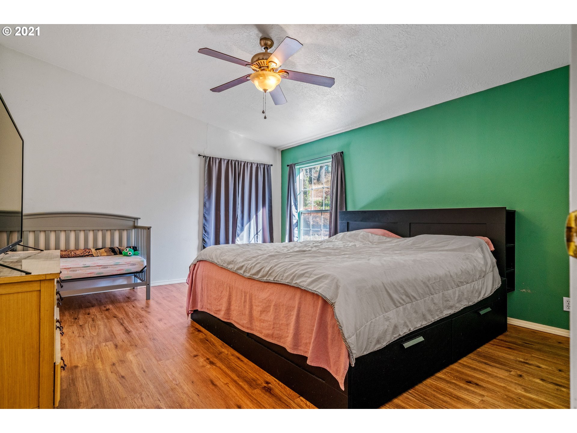 15010 Ferns Corner Road Dallas, OR 97338 - Photo 22 of 32 a bedroom with a bed and a chandelier