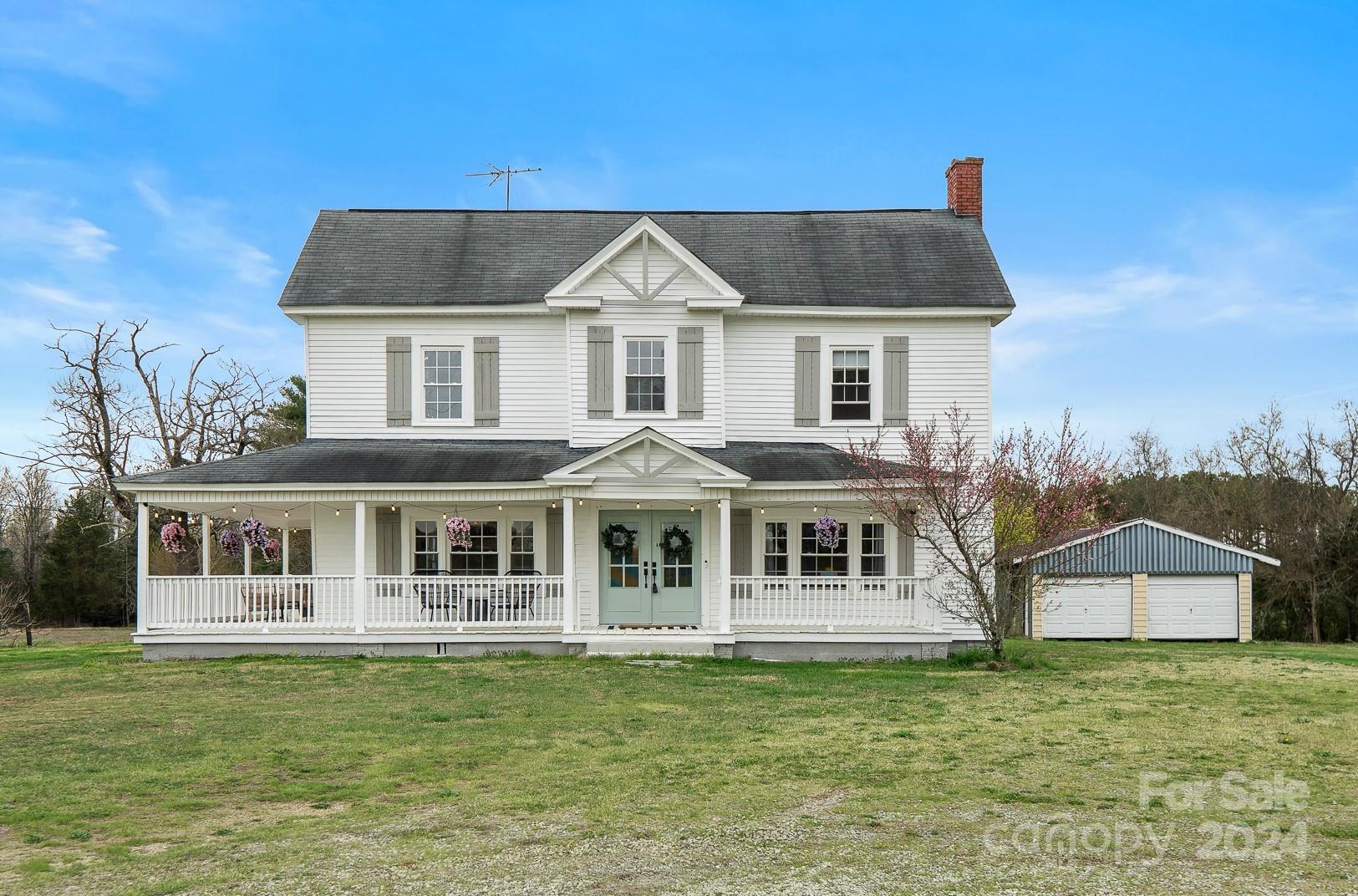 8375 Woodleaf Road Woodleaf, NC 27054 - Photo 1 of 35 a front view of a house with a garden