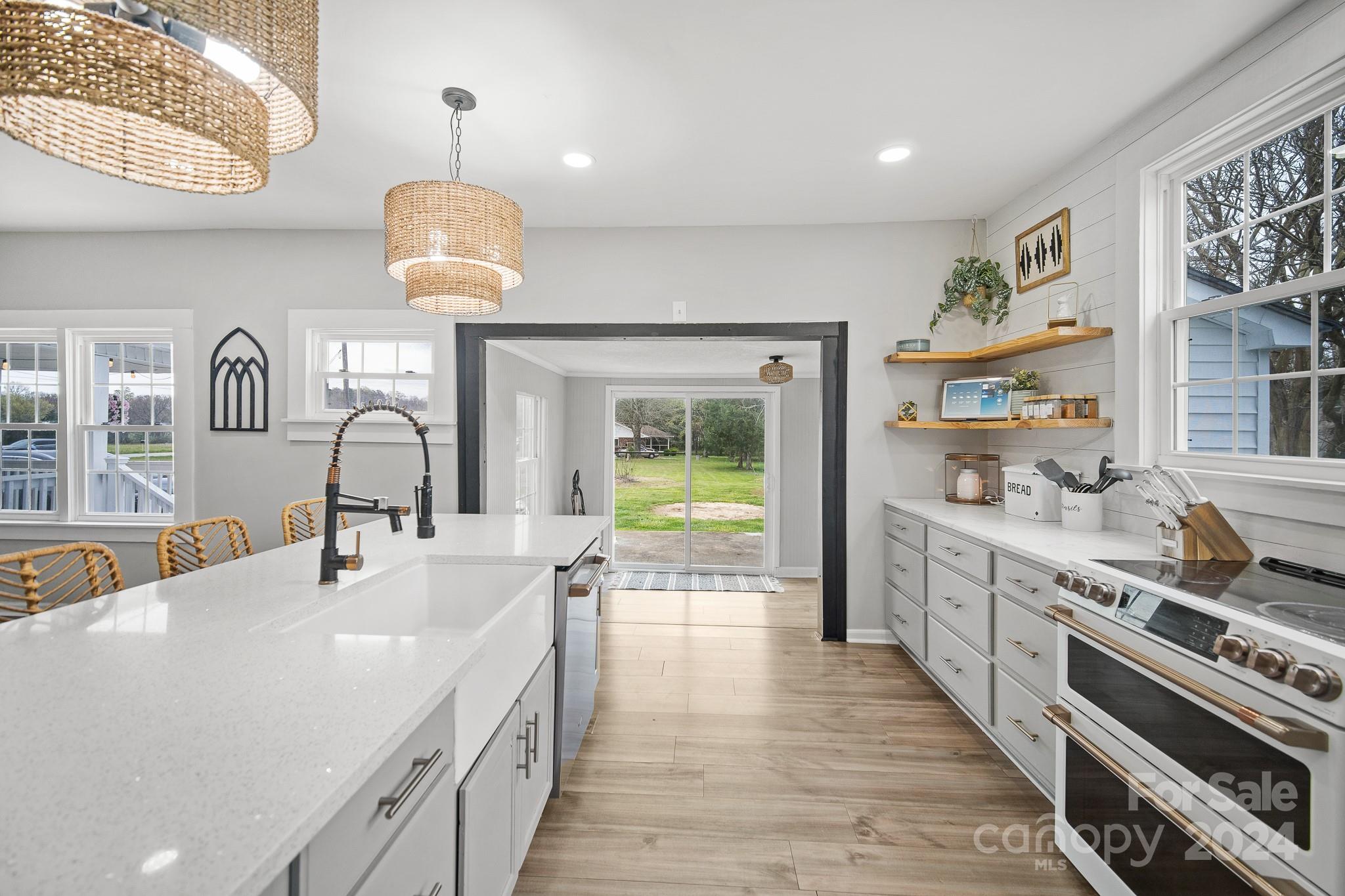 8375 Woodleaf Road Woodleaf, NC 27054 - Photo 5 of 35 a kitchen with kitchen island a large counter top space a sink stainless steel appliances and cabinets