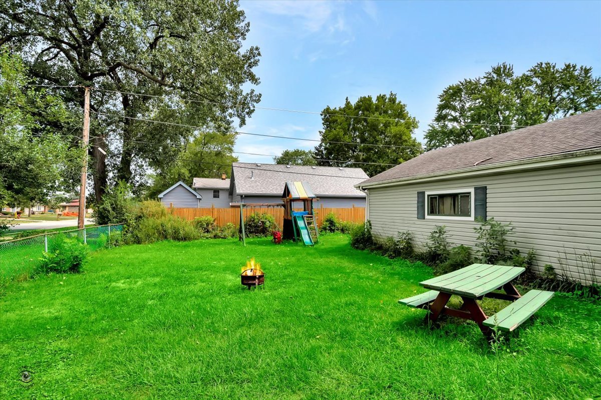 14301 Kilpatrick Avenue Midlothian, IL 60445 - Photo 20 of 22 a view of a backyard with table and chairs and a tree