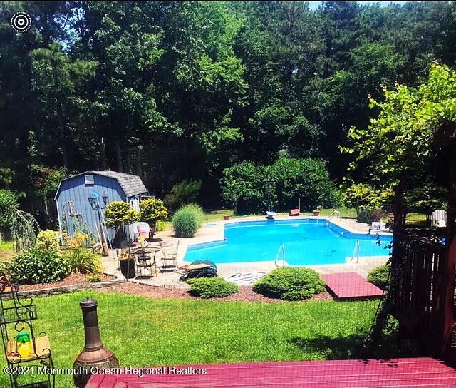 766 Anderson Road Jackson, NJ 08527 - Photo 18 of 21 a view of a swimming pool with lawn chairs under an umbrella