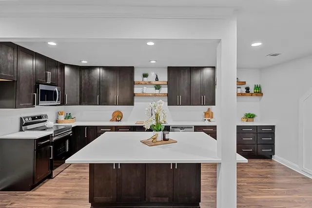 a kitchen with stainless steel appliances a sink a stove top oven a counter space and cabinets