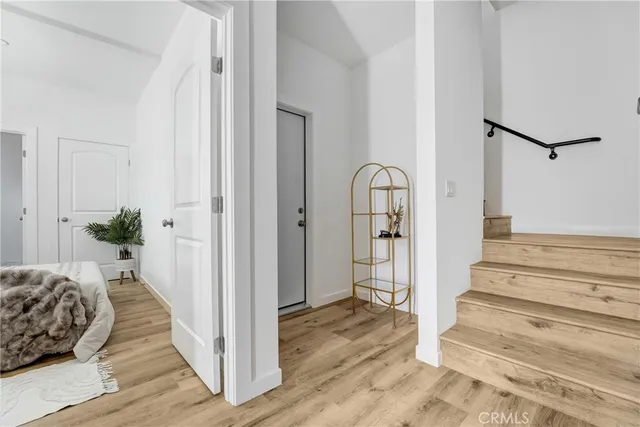 a view of a bedroom with wooden floor and white walls