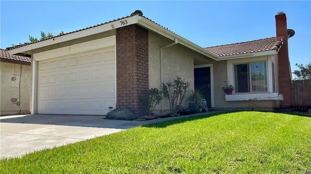 a view of a house with a small yard and a large window