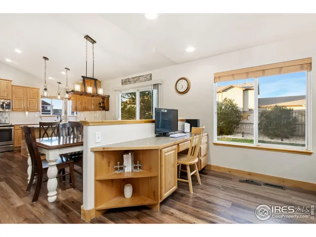 a living room with stainless steel appliances kitchen island granite countertop furniture and a wooden floor