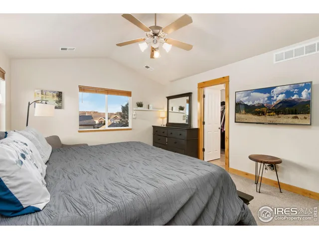 a bedroom with a bed and a painting on the wall