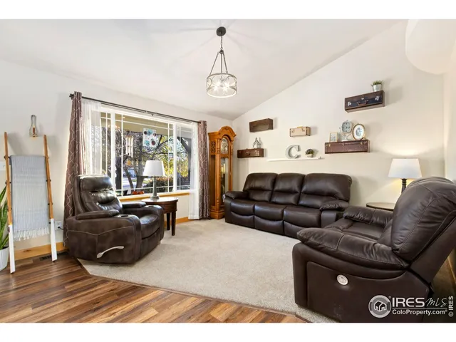 a living room with furniture fireplace and a large window