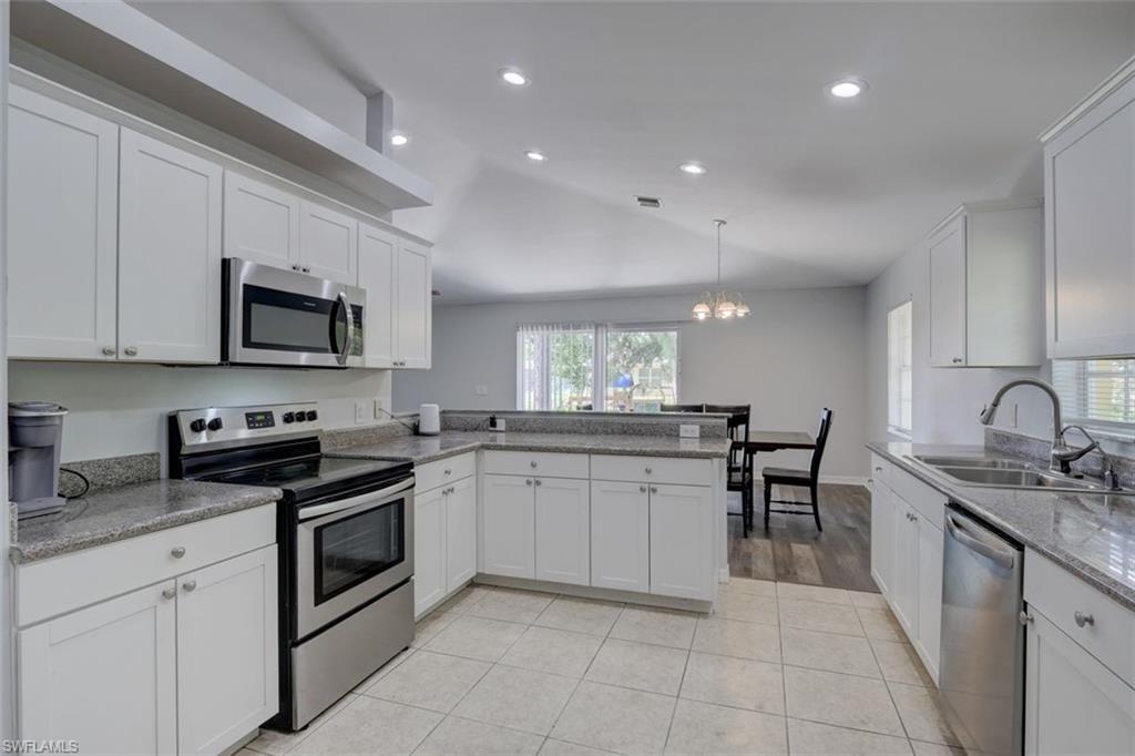 2812 4th Street Southwest Lehigh Acres, FL 33976 - Photo 11 of 34 a kitchen with stainless steel appliances granite countertop a sink and stove top oven