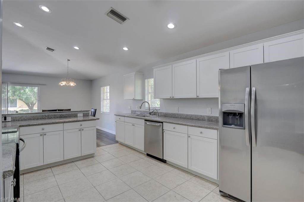 2812 4th Street Southwest Lehigh Acres, FL 33976 - Photo 12 of 34 a kitchen with granite countertop stainless steel appliances and white cabinets