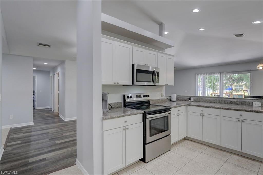 2812 4th Street Southwest Lehigh Acres, FL 33976 - Photo 13 of 34 a kitchen with white cabinets appliances and a sink