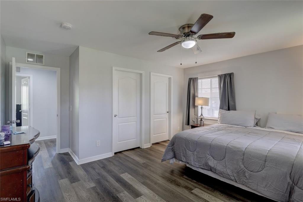 2812 4th Street Southwest Lehigh Acres, FL 33976 - Photo 17 of 34 a bedroom with a bed and a chandelier