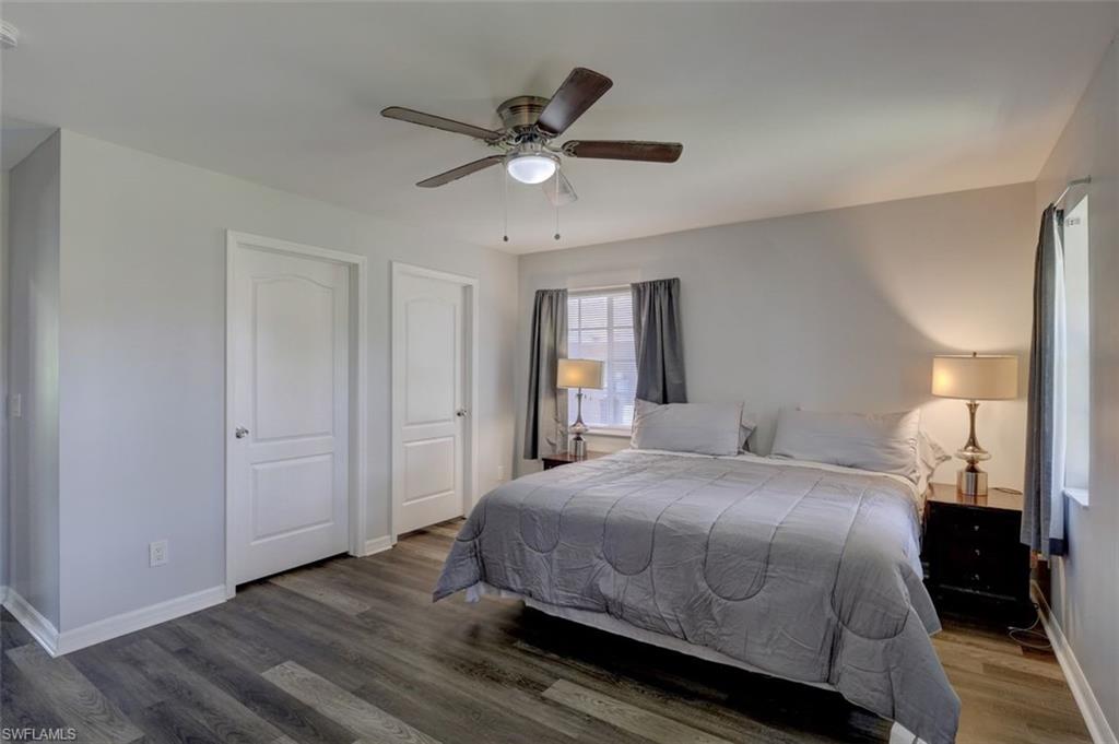 2812 4th Street Southwest Lehigh Acres, FL 33976 - Photo 18 of 34 a bedroom with a large bed and a chandelier