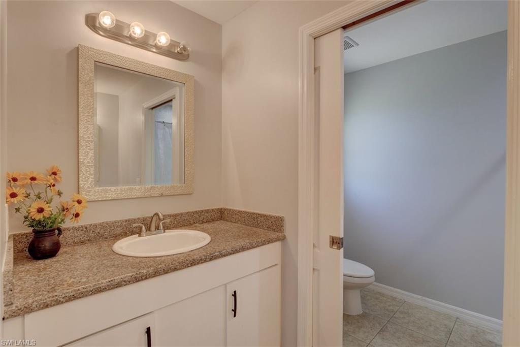 2812 4th Street Southwest Lehigh Acres, FL 33976 - Photo 21 of 34 a bathroom with a granite countertop sink toilet and mirror