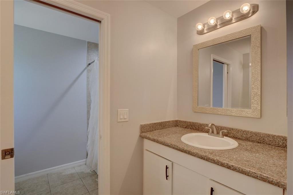2812 4th Street Southwest Lehigh Acres, FL 33976 - Photo 22 of 34 a bathroom with a granite countertop sink and a mirror