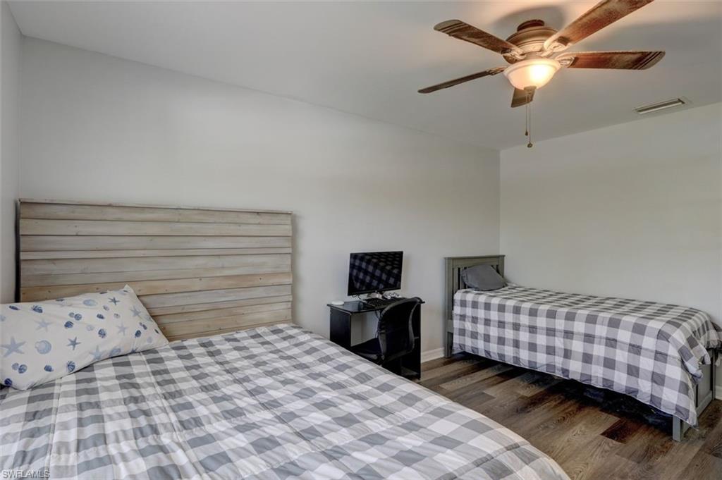 2812 4th Street Southwest Lehigh Acres, FL 33976 - Photo 25 of 34 a bedroom with a bed and a chandelier
