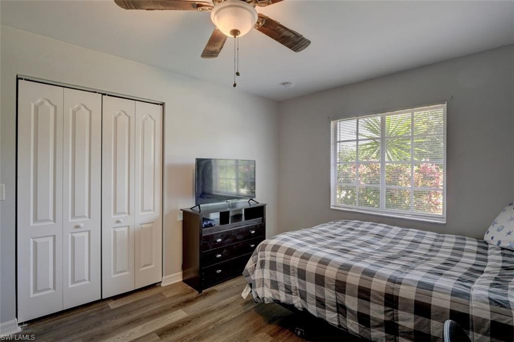 2812 4th Street Southwest Lehigh Acres, FL 33976 - Photo 26 of 34 a bedroom with a bed and a flat tv screen on dresser