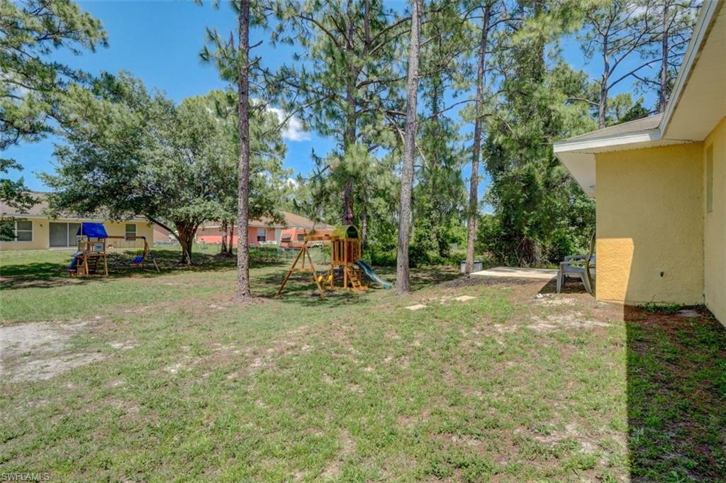 2812 4th Street Southwest Lehigh Acres, FL 33976 - Photo 32 of 34 a view of a yard with a slide