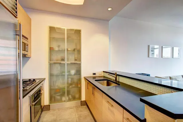 a kitchen with kitchen island a sink appliances and cabinets