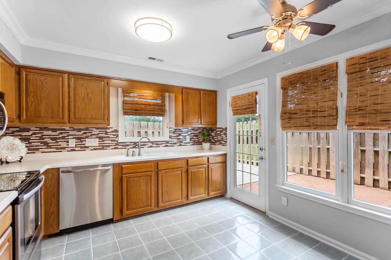 6903 Saxby Court Raleigh, NC 27613 - Photo 3 of 11 The spacious kitchen is open to the family room and features lots of windows, stainless appliances, solid surface & granite counters and a new ceiling fixture. Kitchen