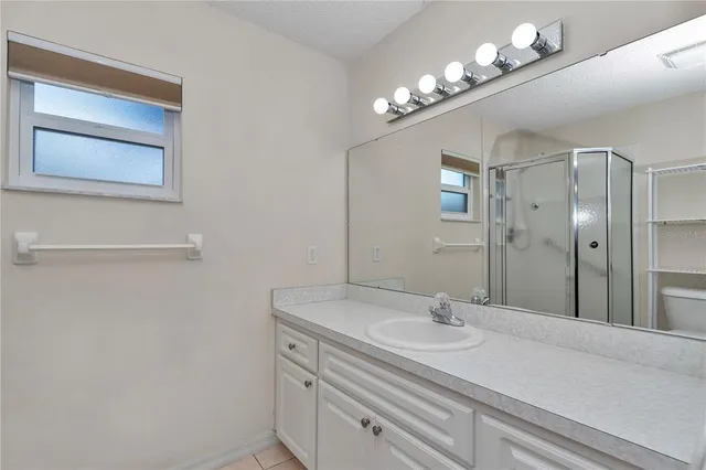 a bathroom with a sink a light fixture and a mirror