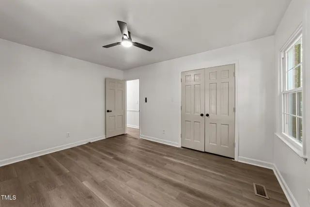 a view of empty room with wooden floor