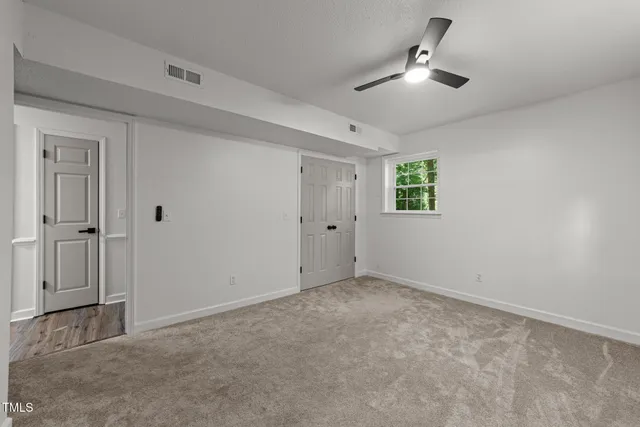 an aerial view of a house with a yard lake and trees all around