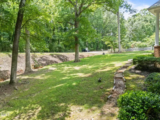 an aerial view of residential house with outdoor space and trees all around