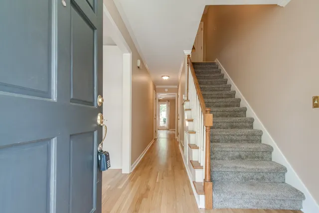 a view of a hallway with wooden floor and staircase