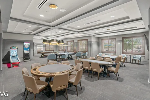 a dining room with wooden floor a chandelier a wooden table and chairs