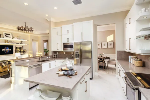 a kitchen with stainless steel appliances a sink a stove a refrigerator cabinets and living room view