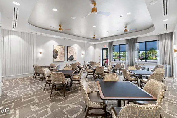 a outdoor space with lots of tables a large window and chairs