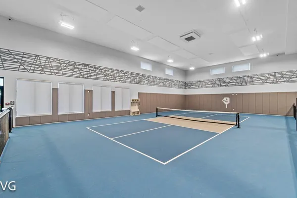 a view of a tennis ground with large trees