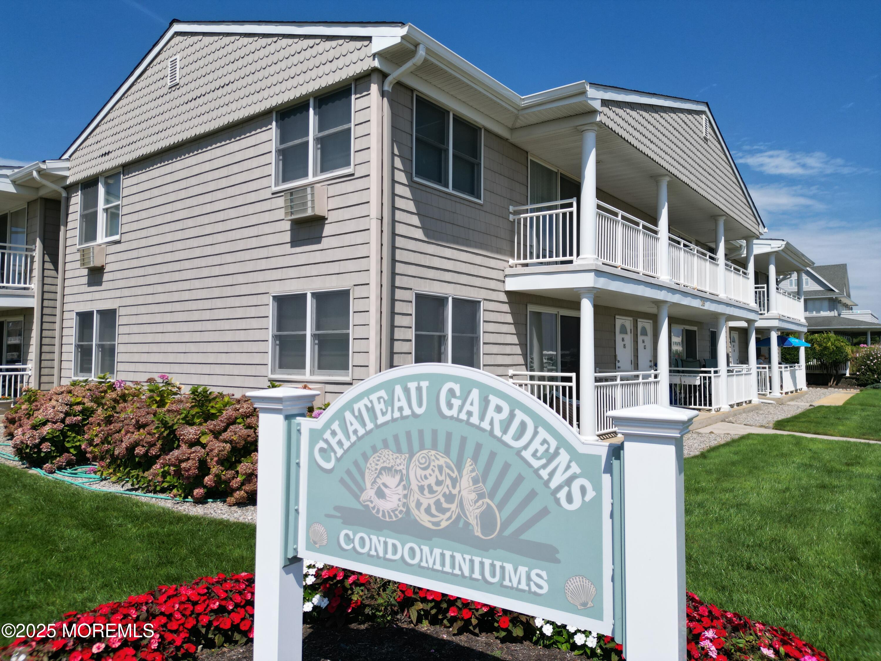 a front view of a house with a garden and signage