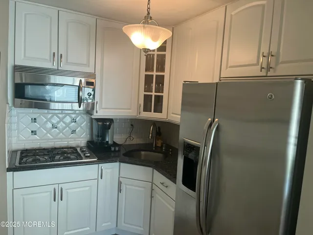 a kitchen with stainless steel appliances granite countertop a refrigerator and a stove