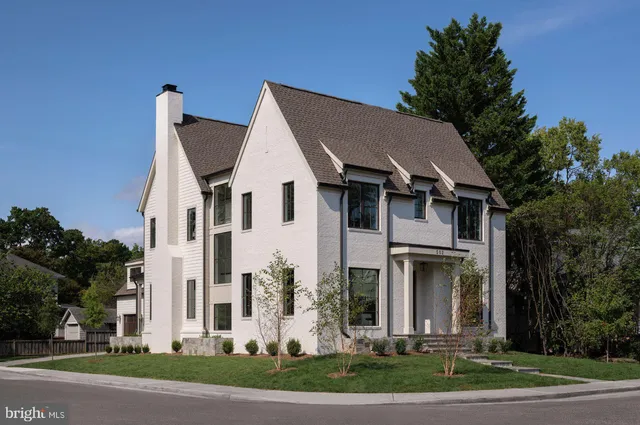 a view of a white house with a yard and plants