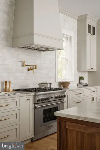 a kitchen with white cabinets and window