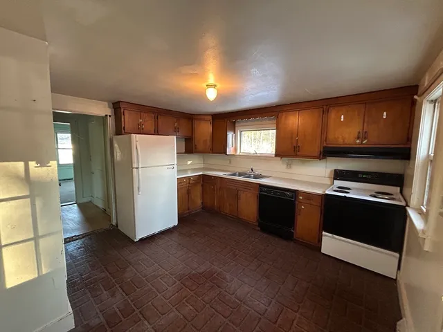 a kitchen with a refrigerator a stove top oven a sink and dishwasher