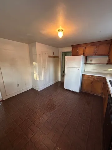 a view of an empty room with a kitchen