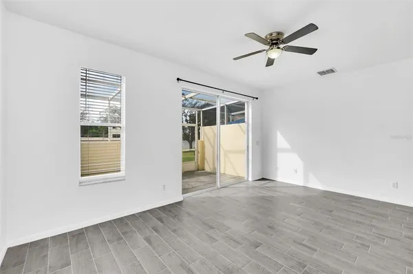 a view of a big room with wooden floor and windows