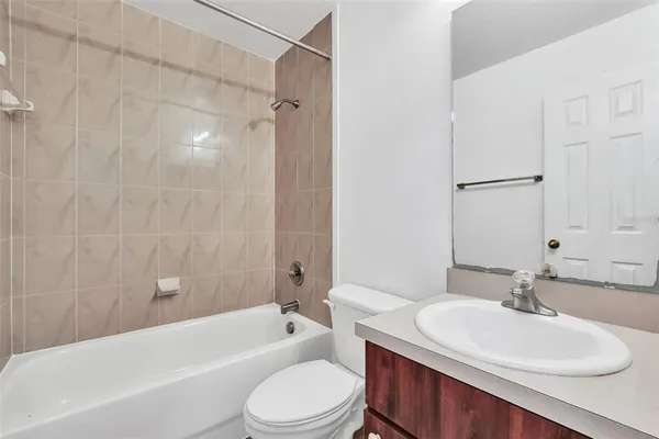 a bathroom with a toilet a sink a mirror a bathtub and shower