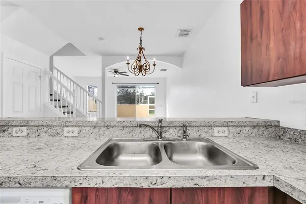 a kitchen with granite countertop a sink stainless steel appliances and cabinets