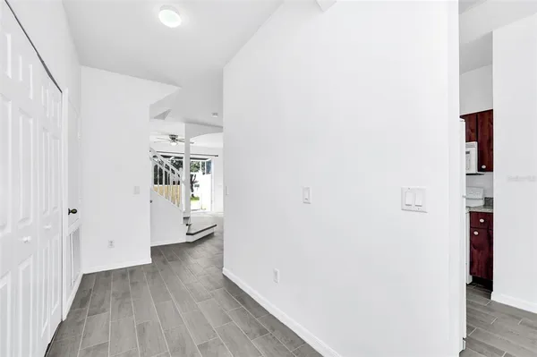 a view of a hallway with wooden floor and closet