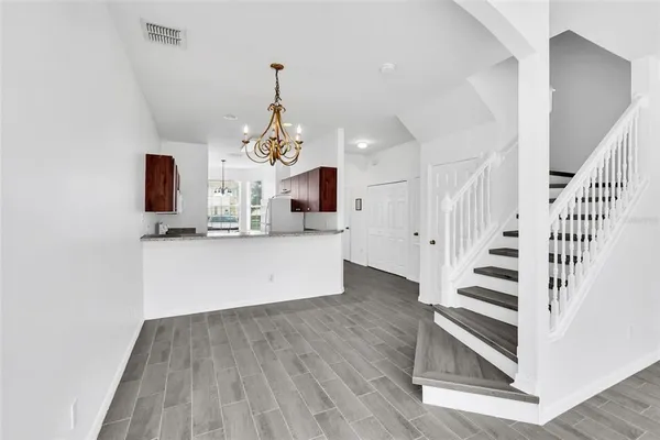 a view of a hallway with wooden floor and entryway
