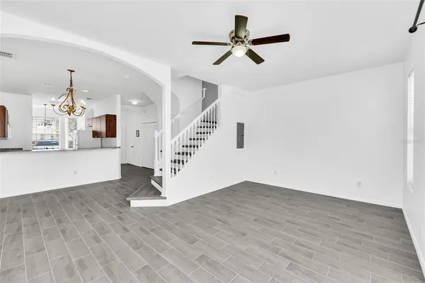 a view of a livingroom with wooden floor and a ceiling fan