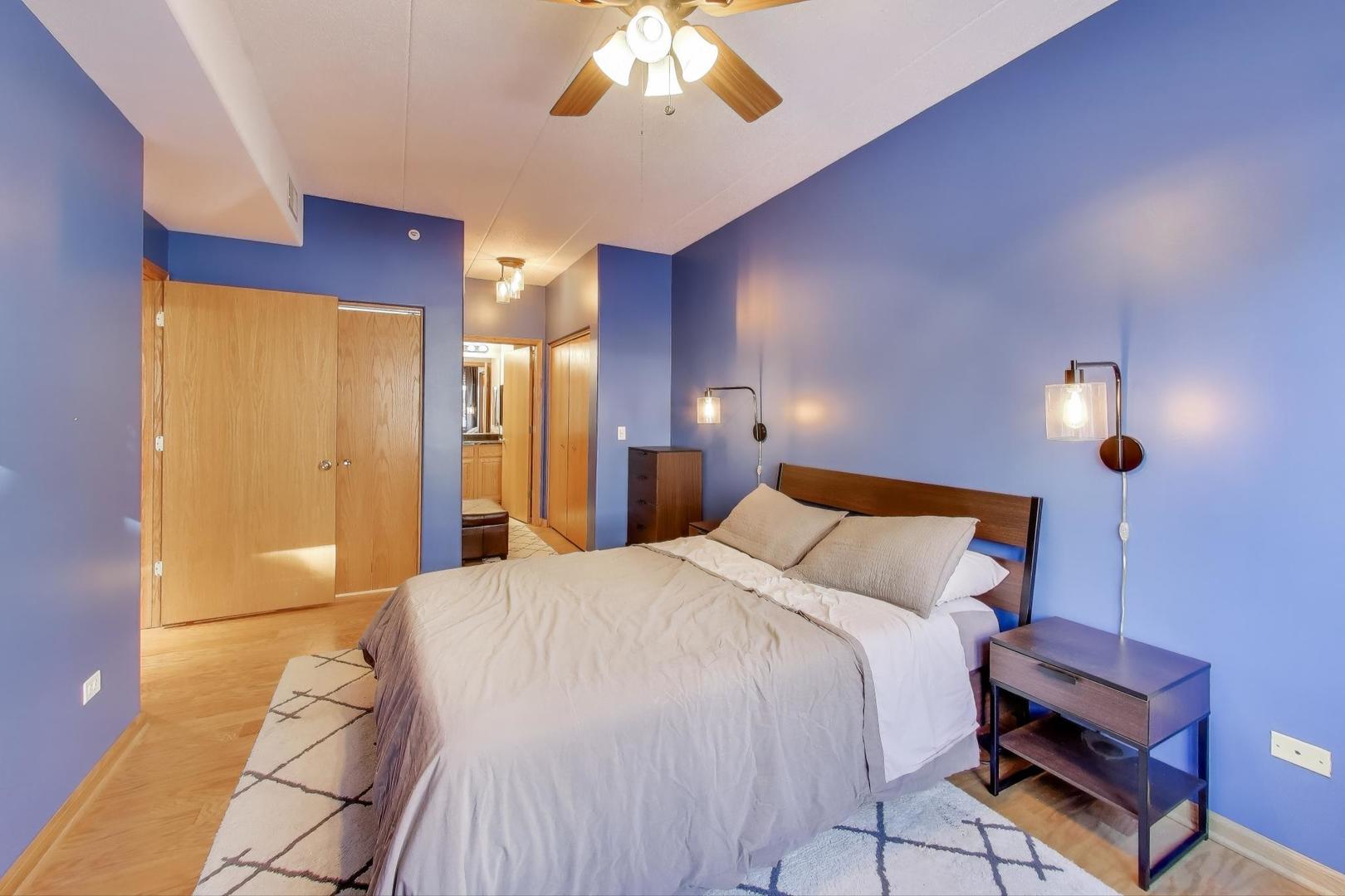 1715 Pavilion Way, Unit 206 Park Ridge, IL 60068 - Photo 11 of 19 a spacious bedroom with a bed and a chandelier